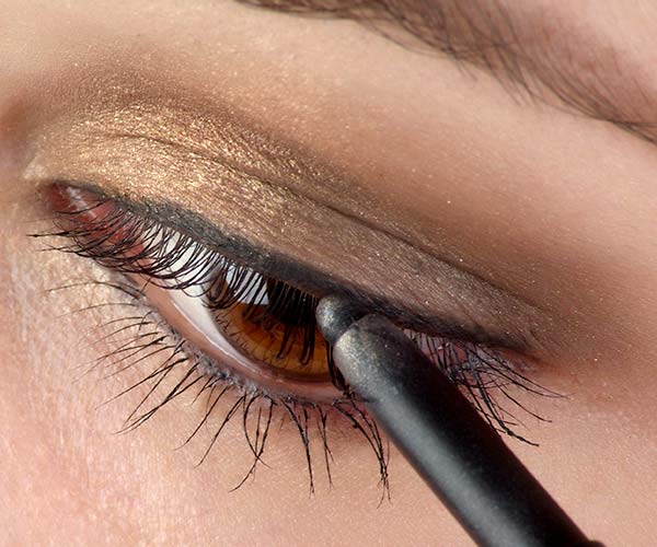 woman putting on eyeliner