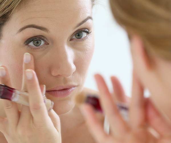 woman applying concealer