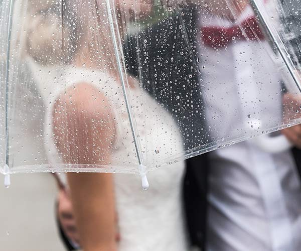 Bride and groom under umbrella