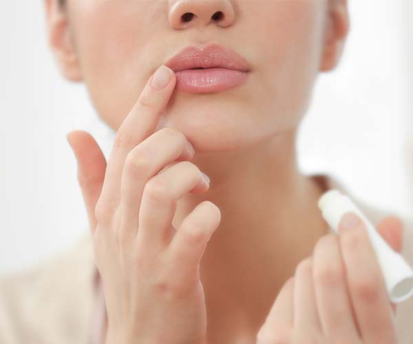 woman applying lip balm