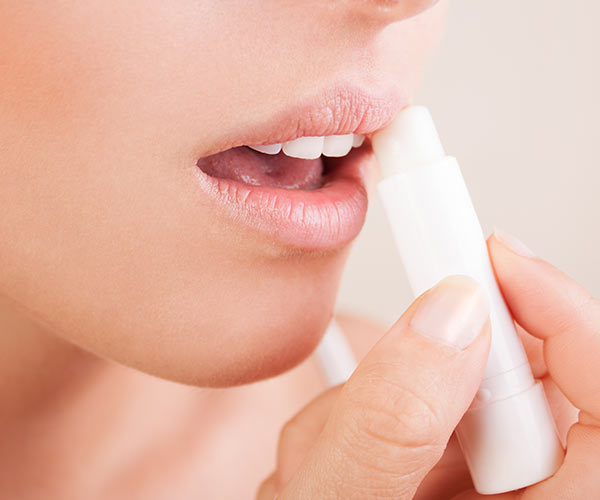 woman applying lip balm