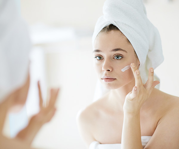 woman applying moisturizer