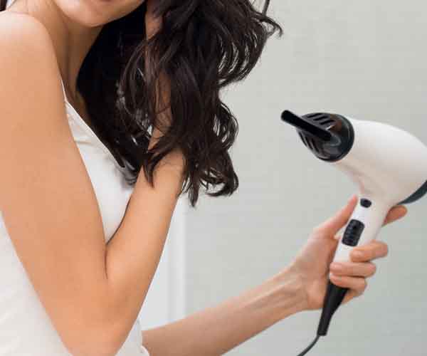 woman blow drying hair