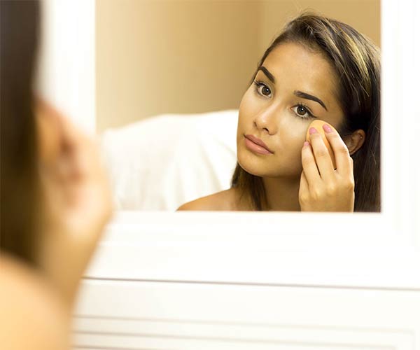 woman applying foundation