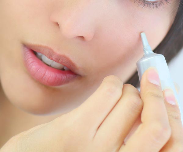 woman applying makeup to face