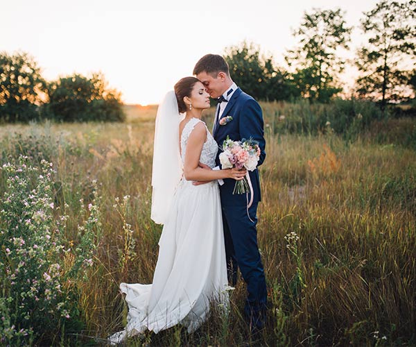 bride and groom posing for outdoor wedding photo