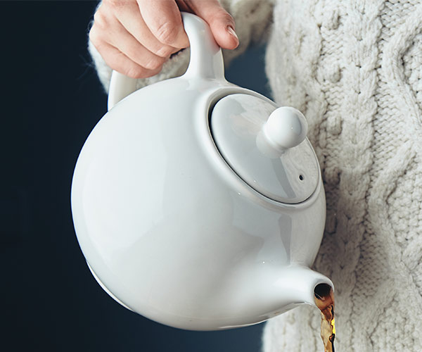 white tea pot pouring tea