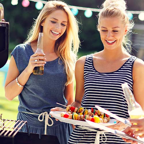 women at barbecue eating food