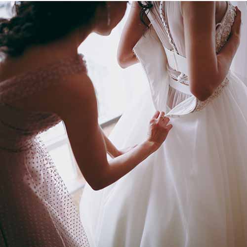 Bride putting on gown