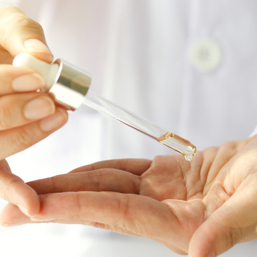 woman using a yellow face serum