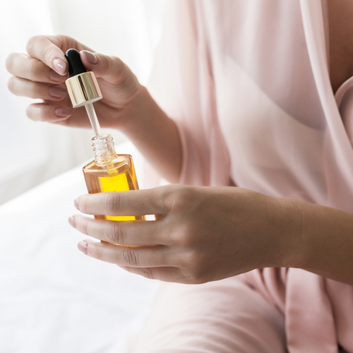 woman using serum in robe