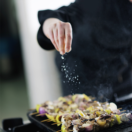 A person seasoning food.