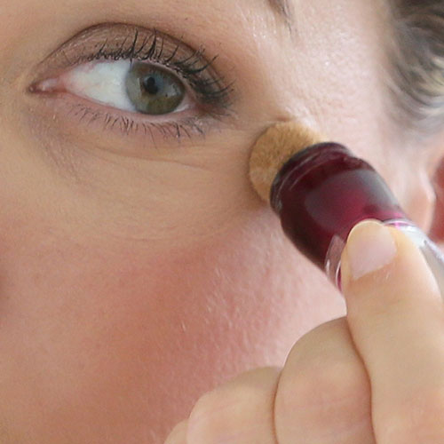 woman applying concealer