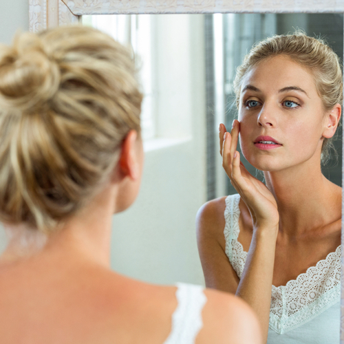 woman looking in mirror