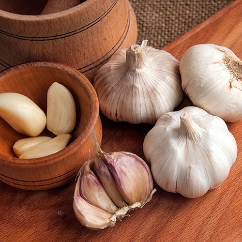 Heads of garlic on a wood board.
