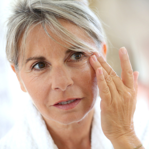 older woman touching face