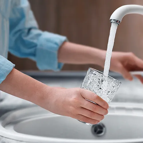A person filling up a glass of water.