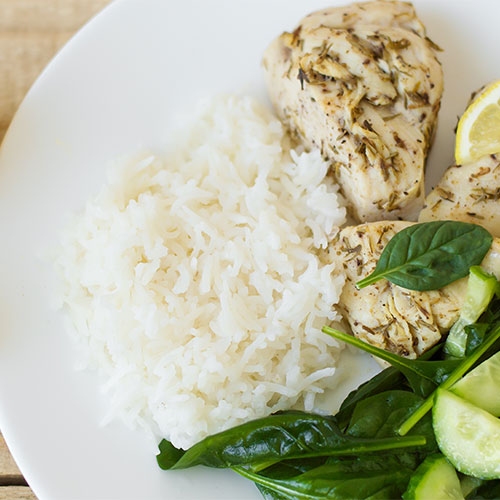 White rice and baked chicken on a plate.