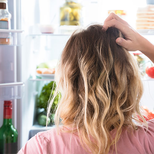 woman looking into fridge