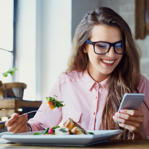 woman eating while on cellphone