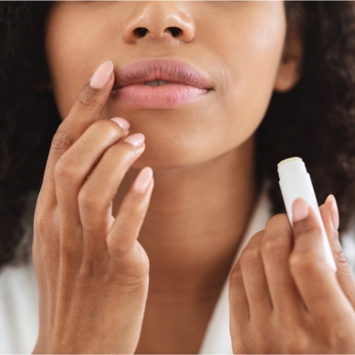 woman putting on chapstick