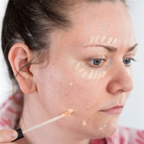 woman applying concealer