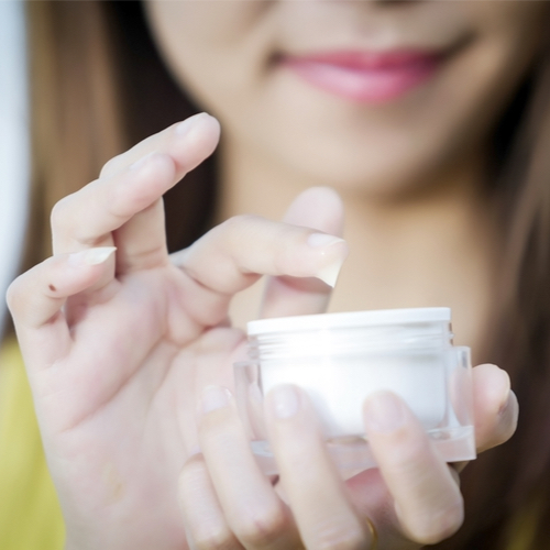 woman using moisturizer