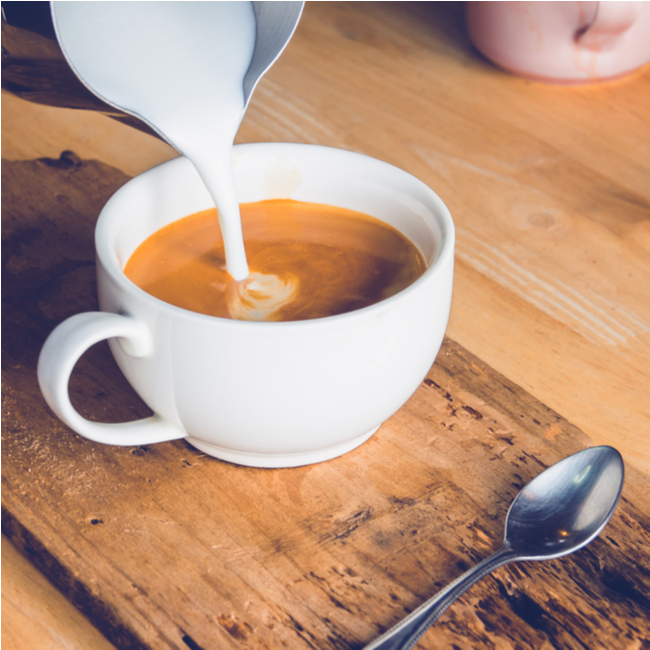 creamer being poured into coffee