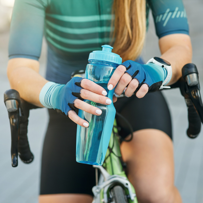 woman holding water bottle on bicycle