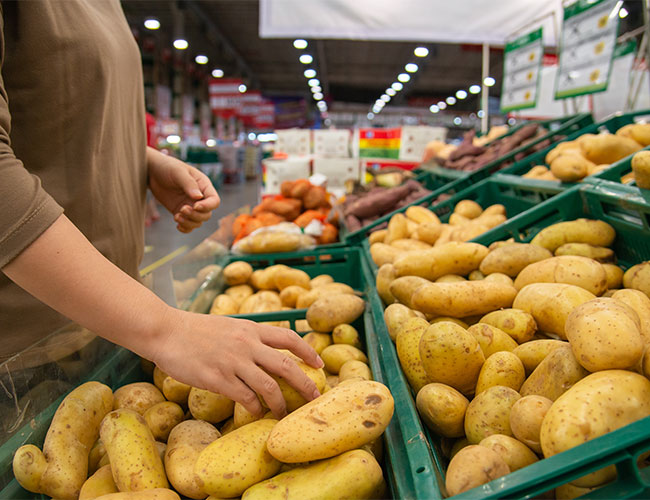 Woman grabbing potato in grocery store