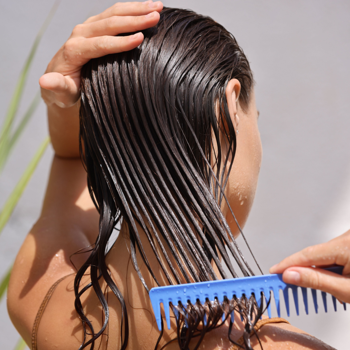 woman combing wet brown hair shower blue comb