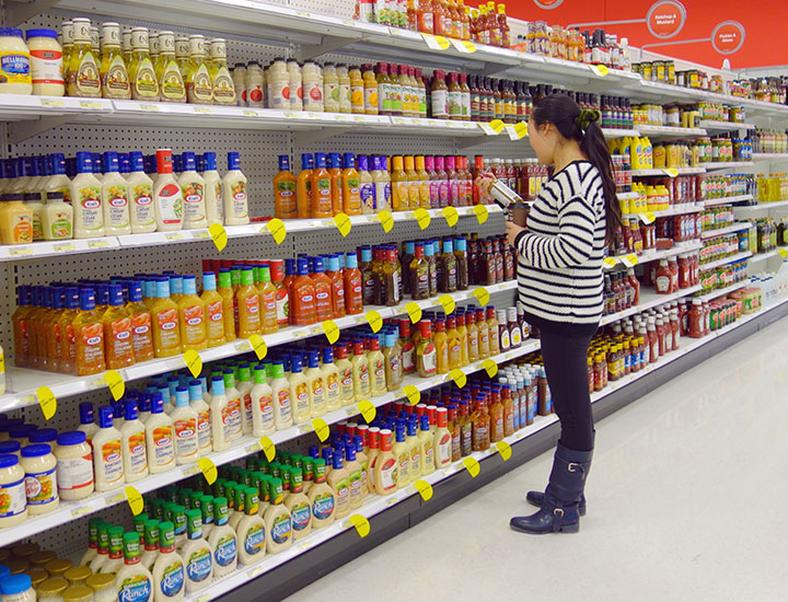 Woman browsing salad dressing aisle in store