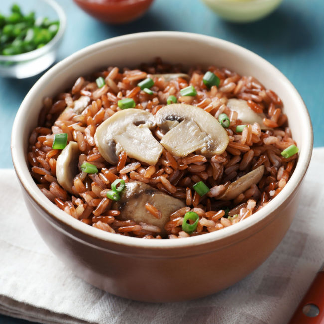 bowl of brown rice with green onions and mushrooms