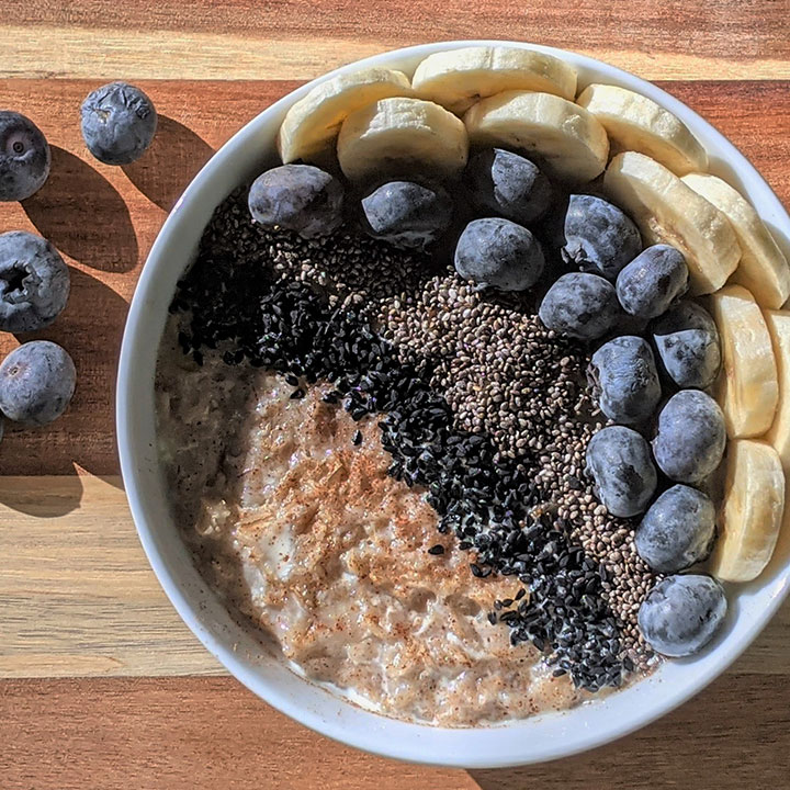 bowl of oatmeal with chia seeds, blueberries, and banana slices