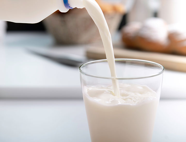 Pouring a glass of oat milk