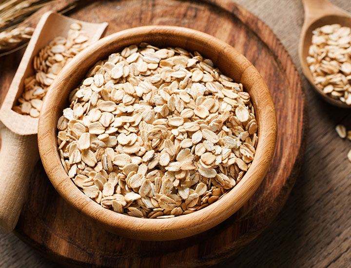 Wooden bowl of oats and scooper