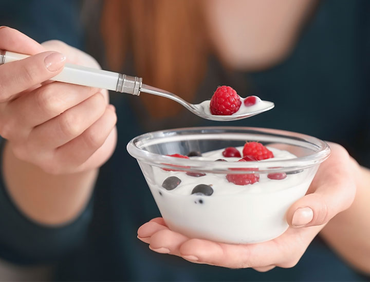 Woman eating a bowl of yogurt