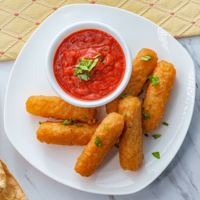 mozzarella sticks on plate with side of marinara sauce