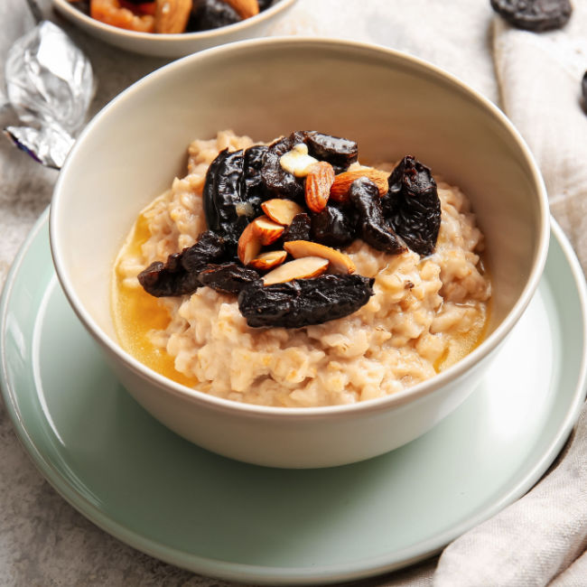 bowl of oatmeal with dried fruit and sliced almonds