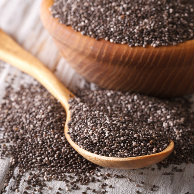 spoonful of chia seeds beside bowl of chia seeds