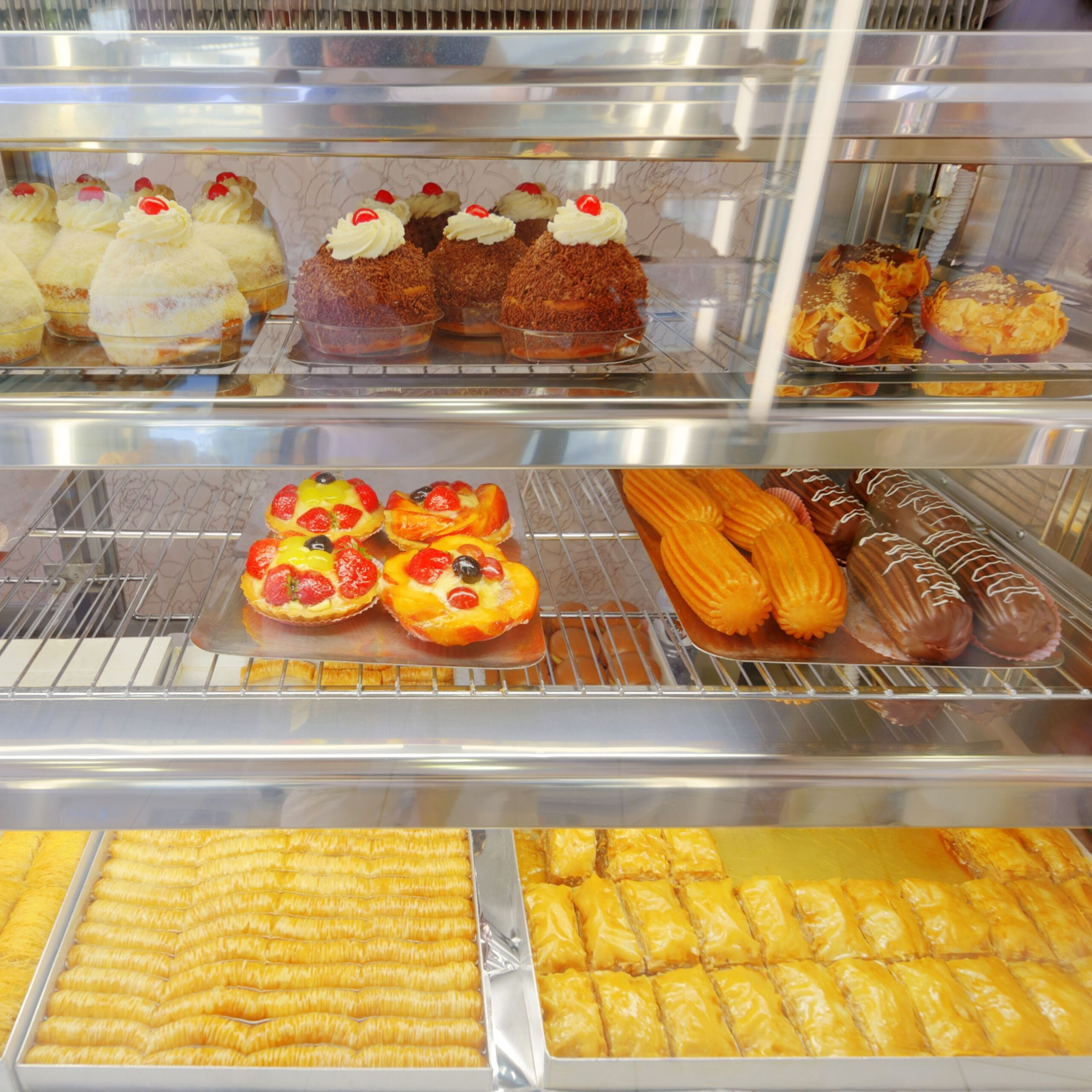 pastry case filled with cupcakes and more