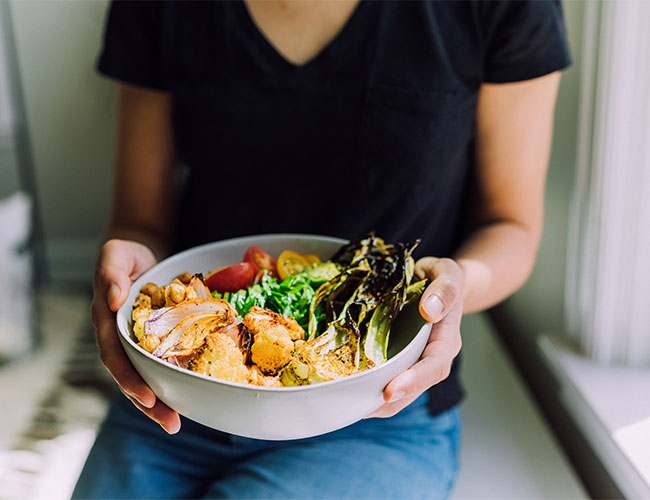 woman holding plant-based bowl