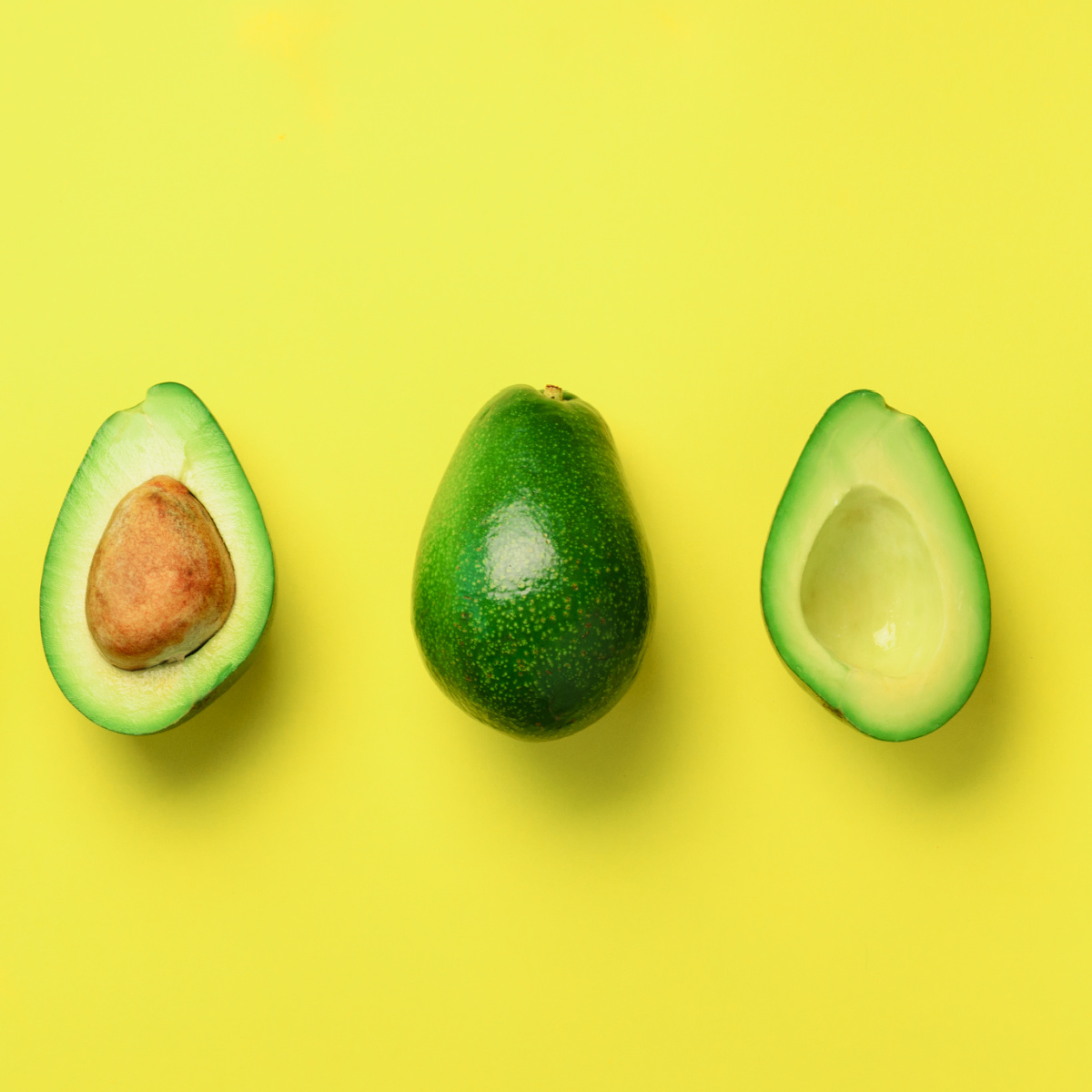 Avocados on a yellow background.