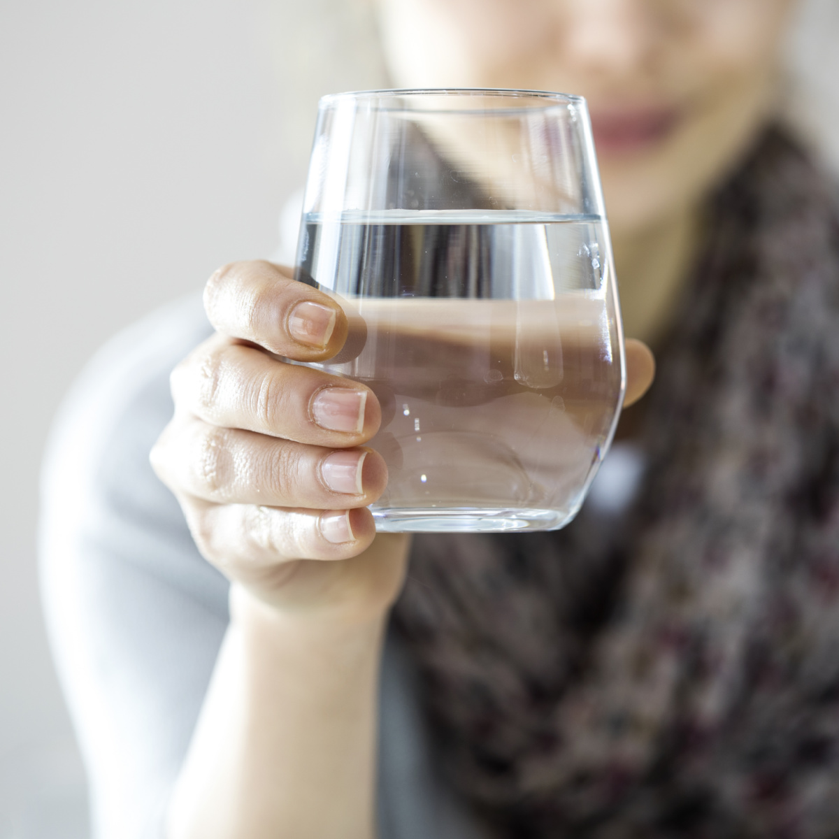 Person holding a glass of water.