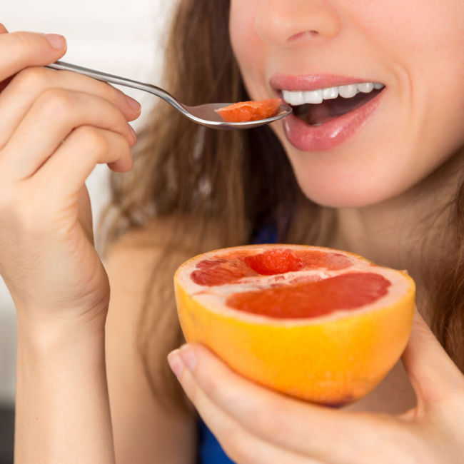 woman eating grapefruit with a spoon