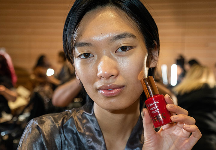 model poses with Sajic Skincare backstage at NYFW