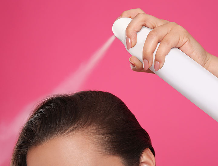 Woman using dry shampoo.