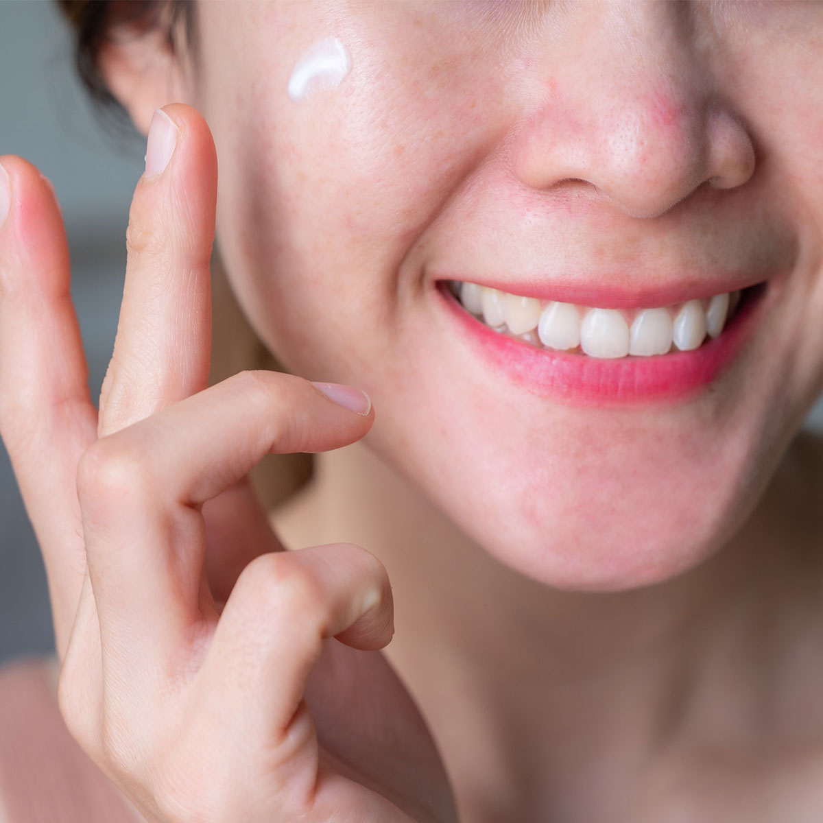 smiling-woman-applying-face-cream