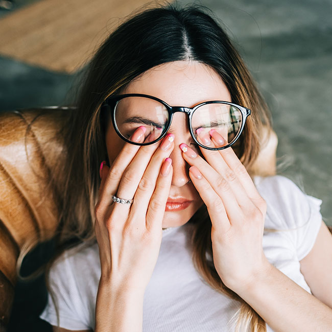 young woman rubbing eyes