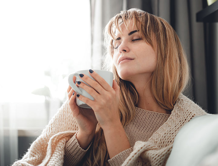 Woman enjoying a warm cup of tea